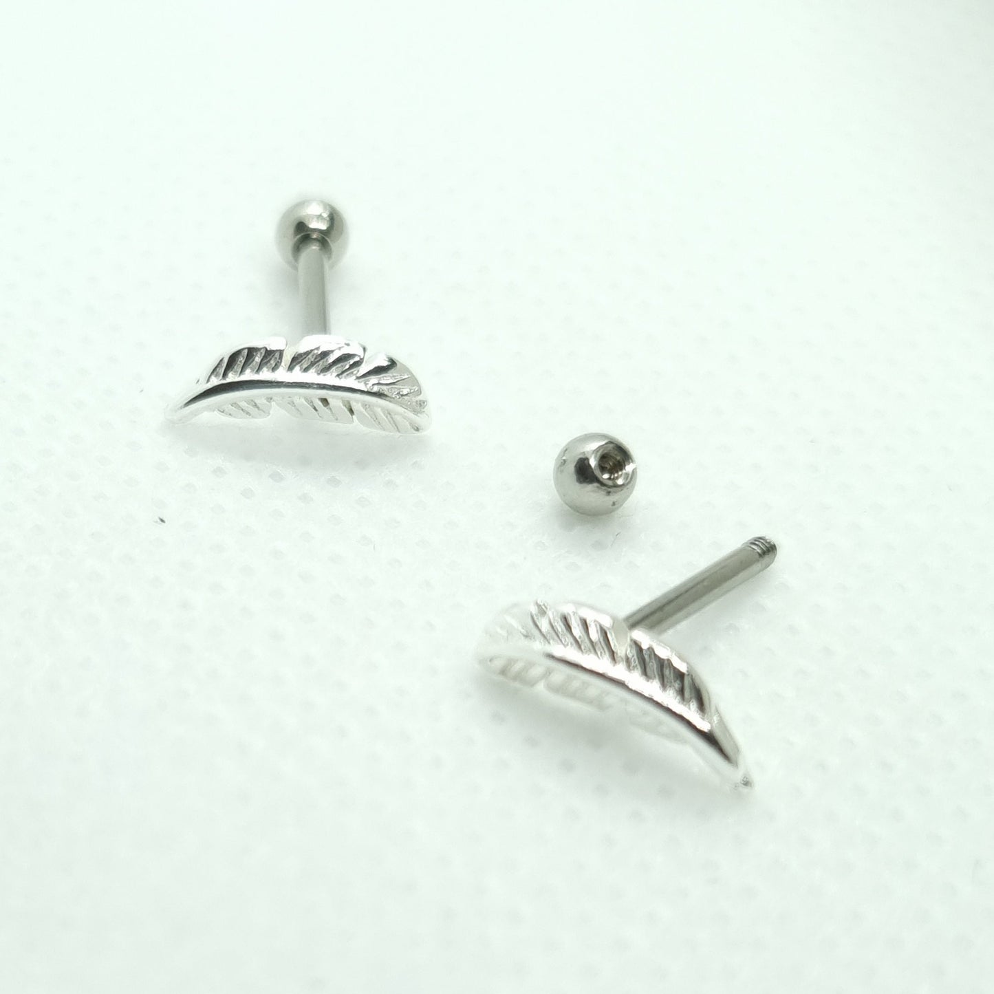 Tragus Piercing barbell with feather shaped top and a 3mm steel ball ( 316L surgical steel )